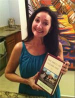 Beverly holding her novel The Smell of Sugarcane